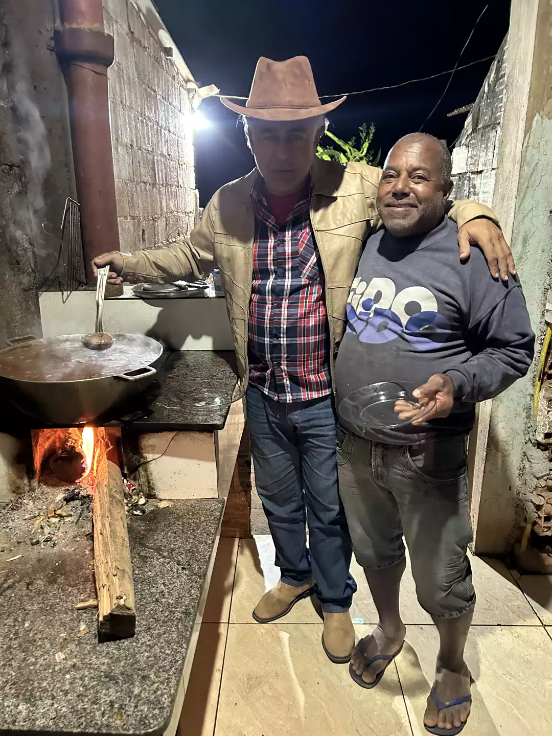 Amauri Damião com morador ao lado do fogão a lenha na comunidade de Córrego São João